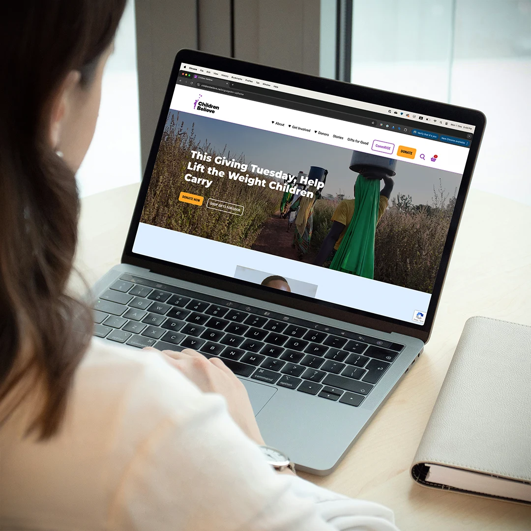 Woman looking at Children Believe website on a laptop