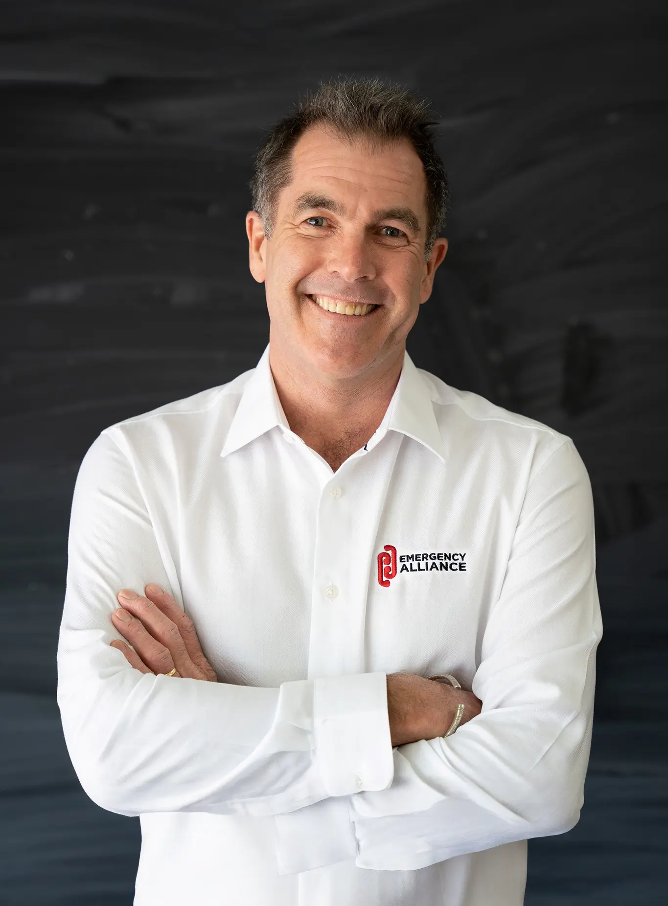 Man with crossed arms smiling at the camera in a professional image