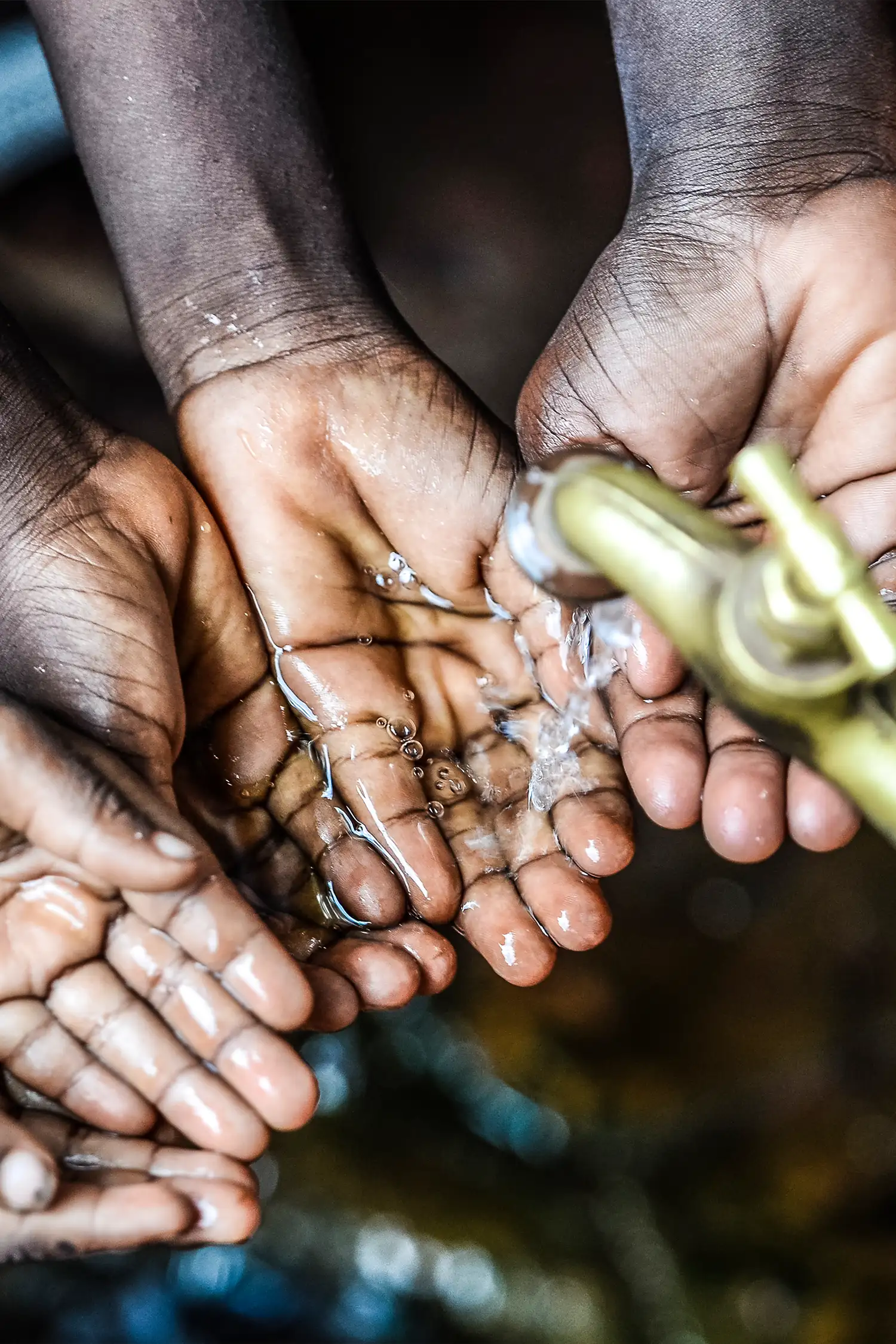 Hands with palms up collecting water - the spigot of the tap is visible