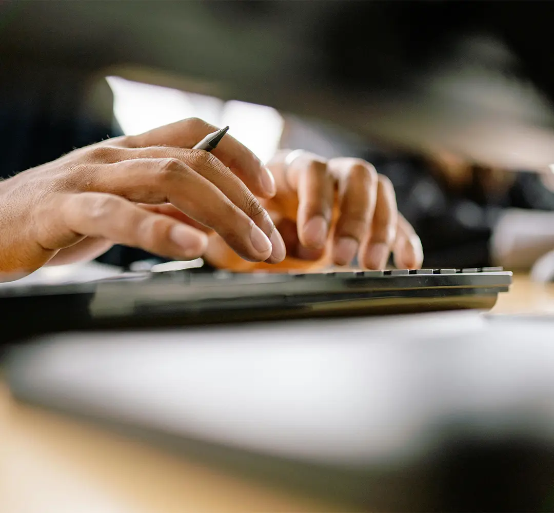 Close up of a man typing on a keyboard. his hands and the keyboard are the only things visible