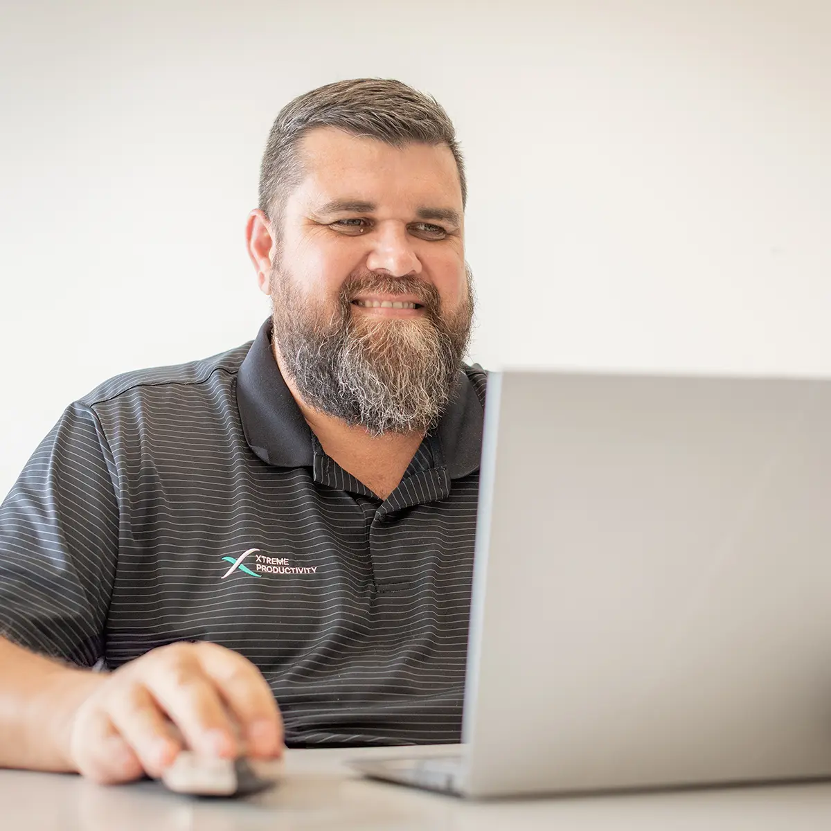 xp staff smiling and looking at laptop